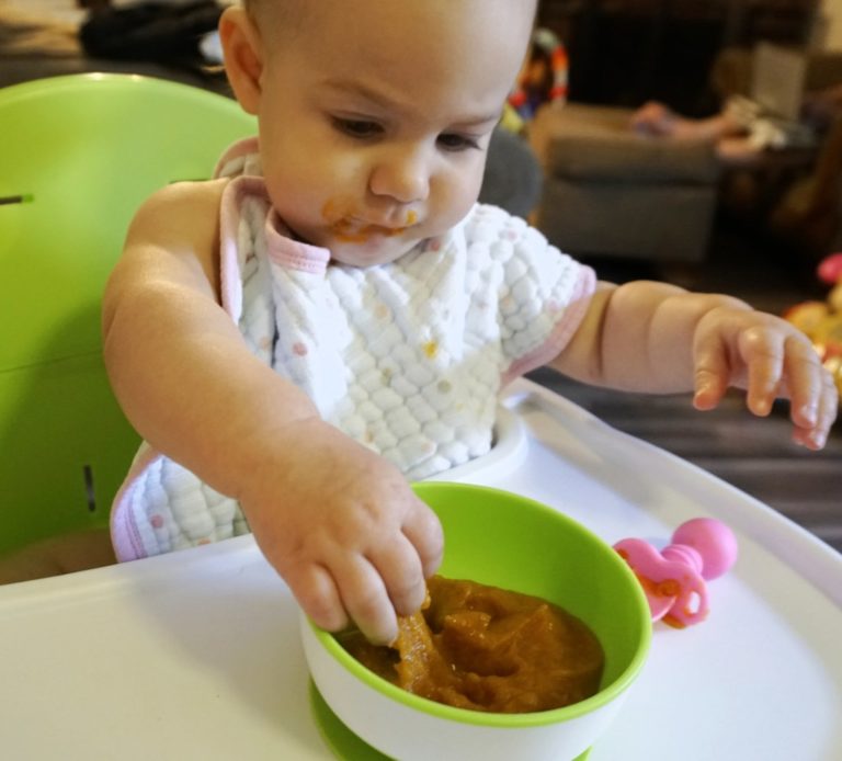 Baby eating harvest puree from a bowl